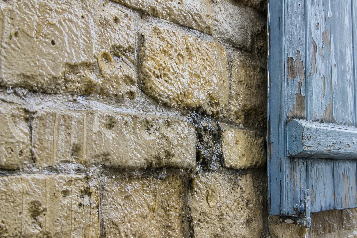 Façade en pierre d&rsquo;une maison normande exposée au vent et à la pluie du littoral