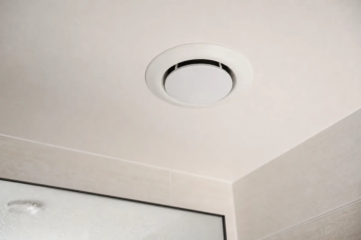 Bouche d&rsquo;extraction de ventilation mécanique au plafond d&rsquo;une salle d&rsquo;eau claire